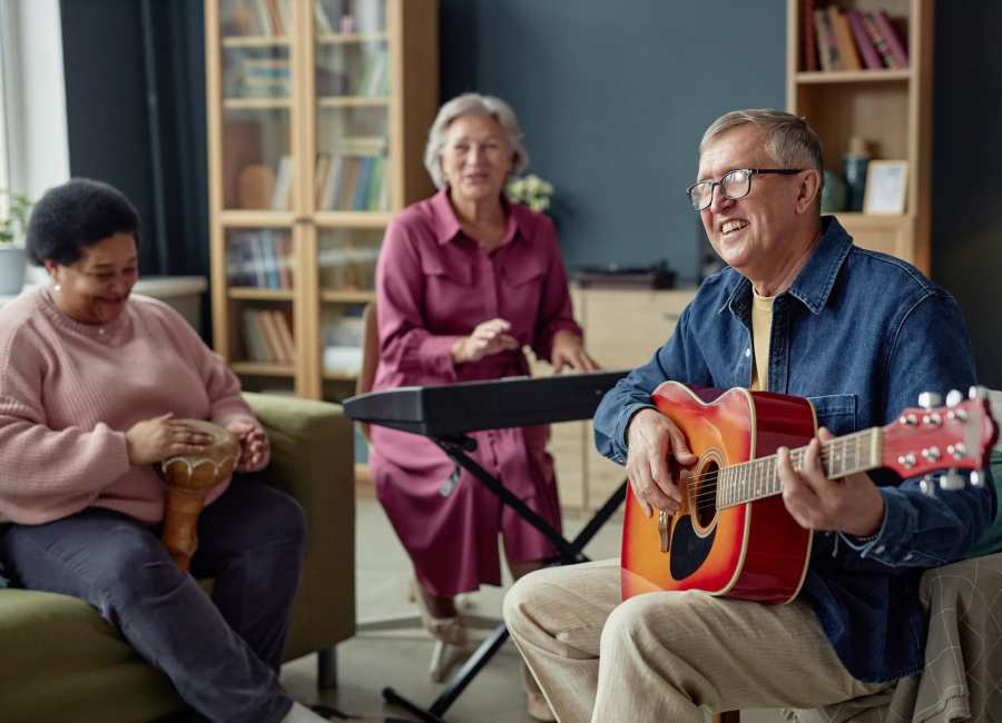 Happy residents playing music instruments at Homestead Village Pensacola in Pensacola, Florida