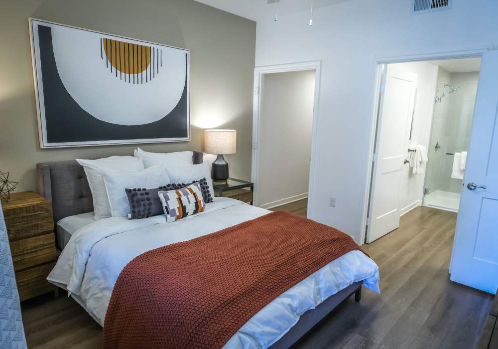 Model bedroom with wood-style flooring at The Courtyards Pacific Village in San Diego, California