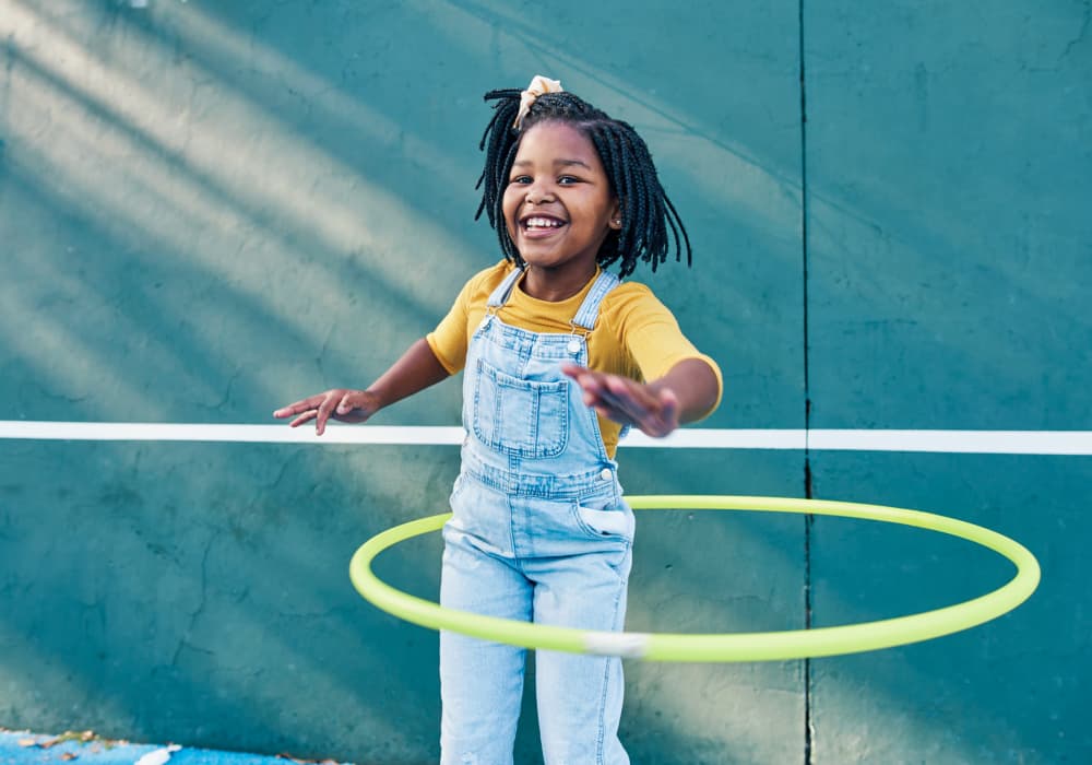 Young girl playing with the hula hoop near Broadway Crossing Apartments in Merrillville, Indiana