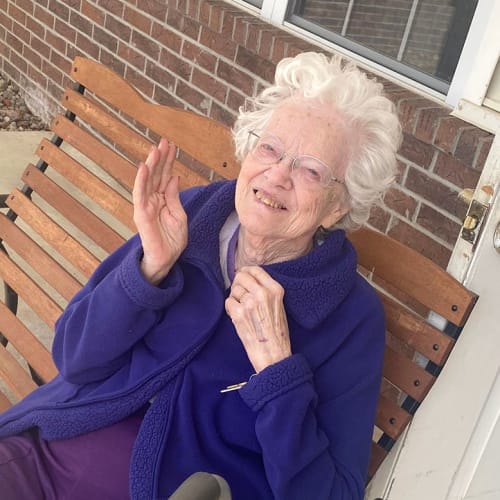 Smiling resident with fun hat and dessert at Saunders House in Wahoo, Nebraska