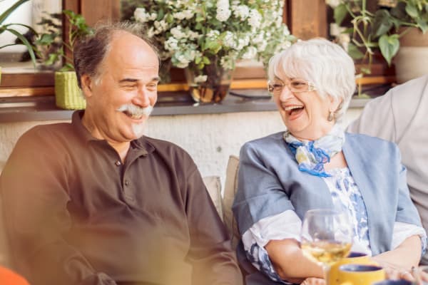 A resident couple laughing at The Grand Court Senior Living in Mesa, Arizona. 