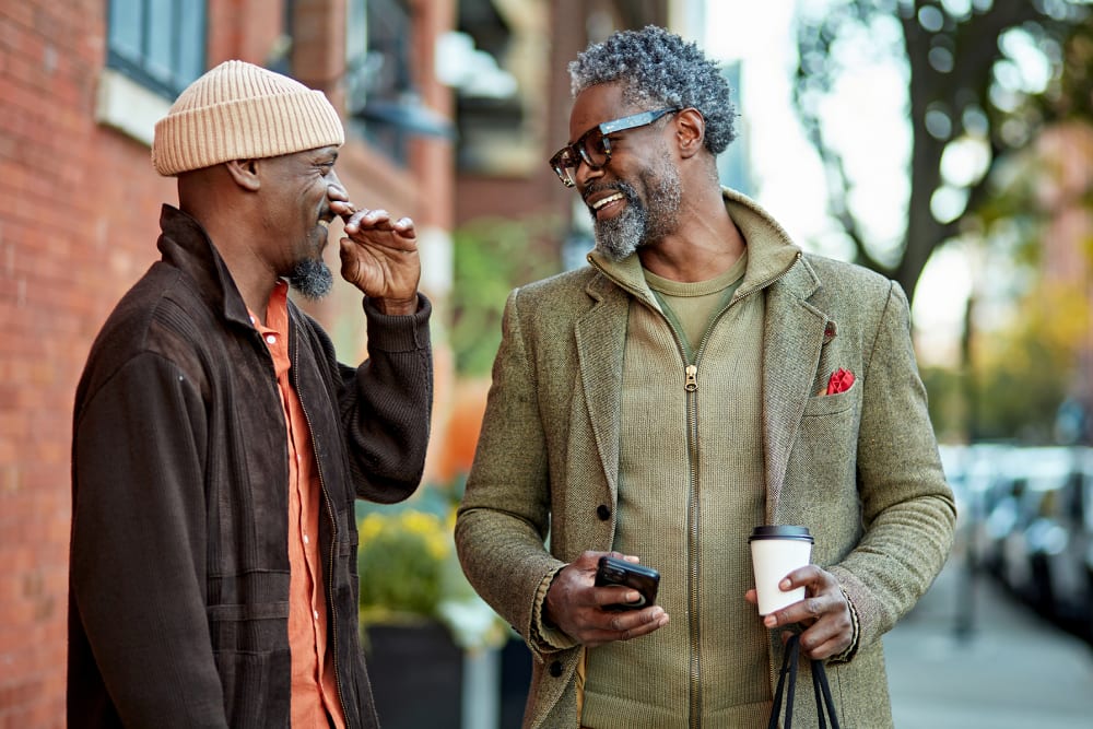 Two residents having coffee on a walk in the city near The Millton in Redwood City, California