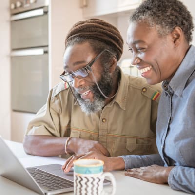 Resident couple using a laptop inside their apartment at a Ebenezer Senior Living community