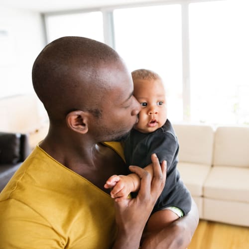 A father holding his son in a home at Fairway Heights in Twentynine Palms, California