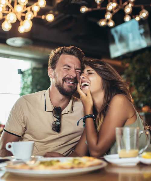 Partners having a happy moment while relishing a meal at a cafe near The Edison at Riverwood in Hermitage, Tennessee