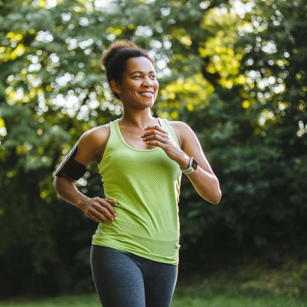 Happy resident jogging in a park near Breeze Apartments in Gulf Breeze, Florida