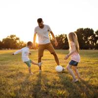 Resident man playing soccer with his children at Regency in Sherman Oaks, California