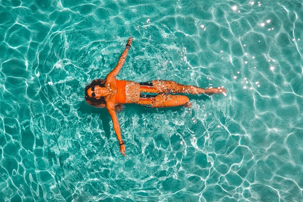 Woman floating in resort style pool at Peralta Vista in Mesa, Arizona