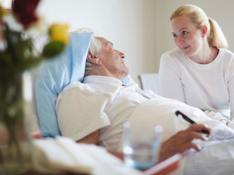 Caretaker sitting and conversing with a resident in hospice care at Retirement Ranch in Clovis, New Mexico