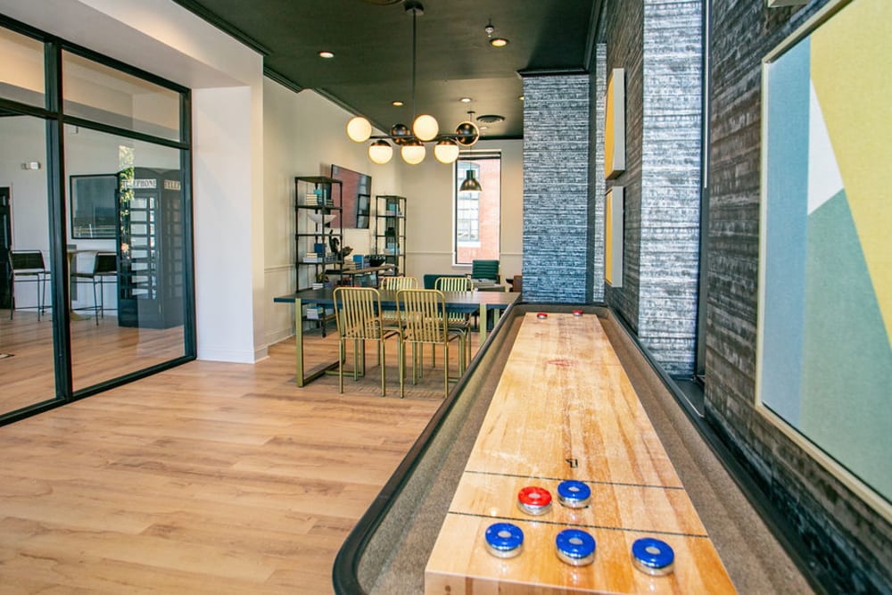 Community clubhouse featuring shuffleboard and community shared space at Lofts at Riverwalk in Columbus, Georgia