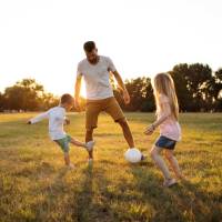 Resident with his kids in a park at Settlers Trail Apartments in Lindale, Texas