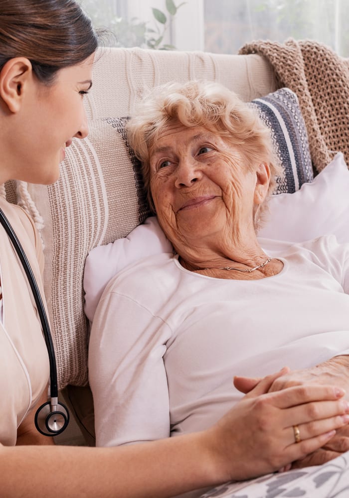 A caregiver attends to a woman in her apartment at Highland Estates in Burley, Idaho