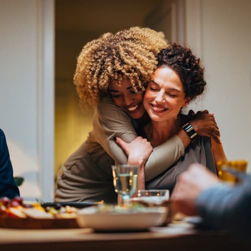 Friends hugging at dinner at Meridian at Stanford Ranch in Rocklin, California