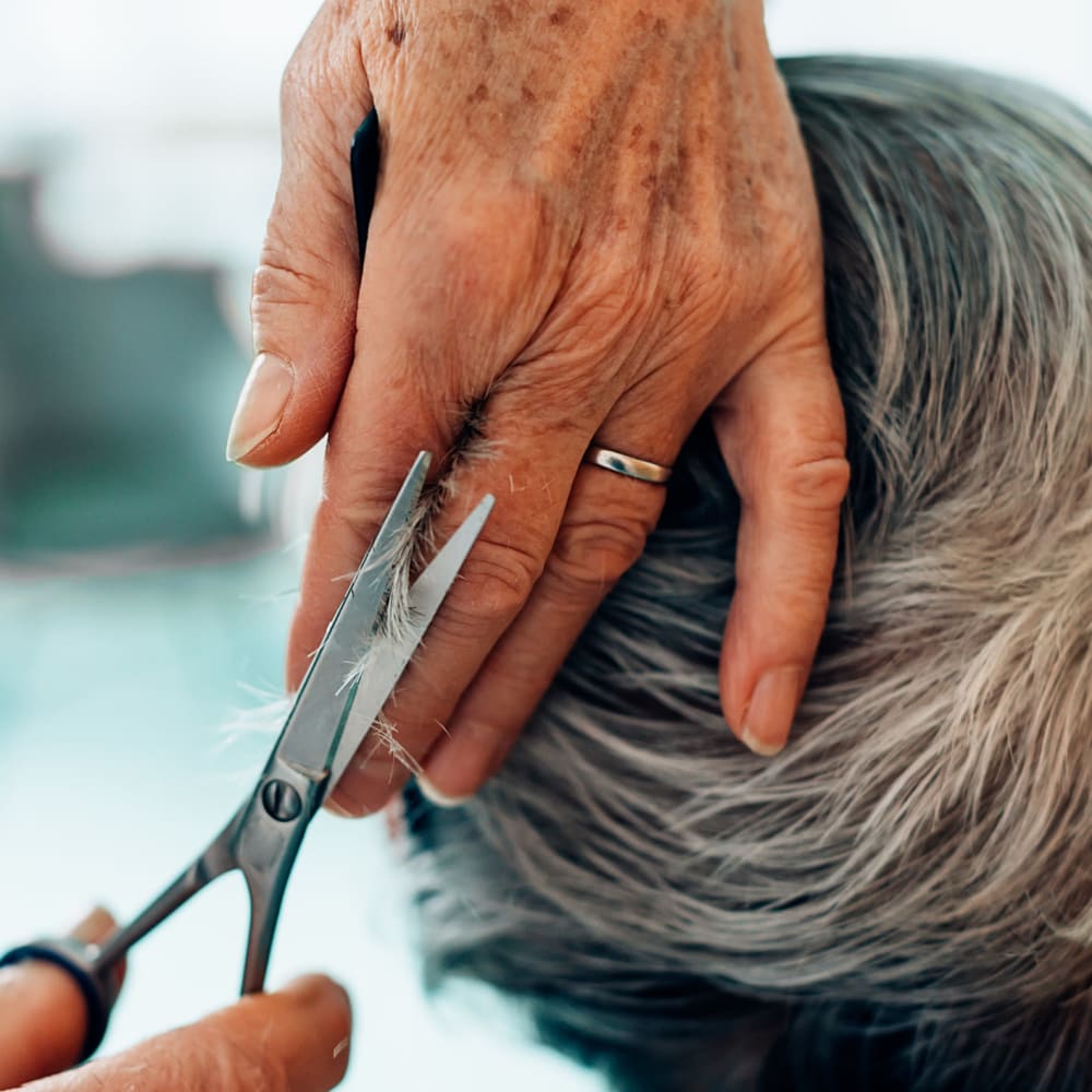 A senior getting their hair cut at Harbor Cove Memory Care in Hilton Head Island, South Carolina