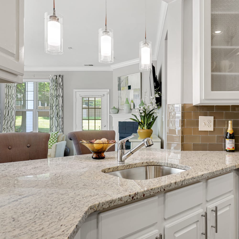 A spacious countertop with a sink in an apartment kitchen at The Courts of Avalon in Pikesville, Maryland