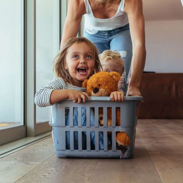 A mom pushes her kids in a laundry hamper at Mason Avenue, Alexandria, Virginia