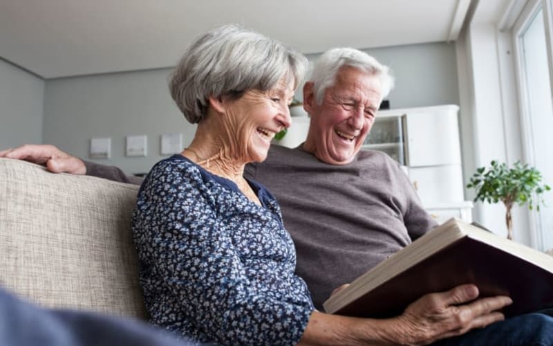 Residents looking through a photo album at Grand Villa of St. Petersburg in St. Petersburg, Florida