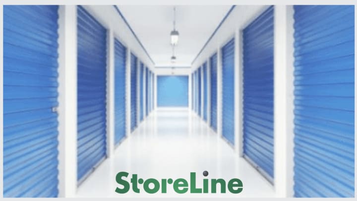 A clean white and blue hallway lined with storage units with the StoreLine logo in the bottom