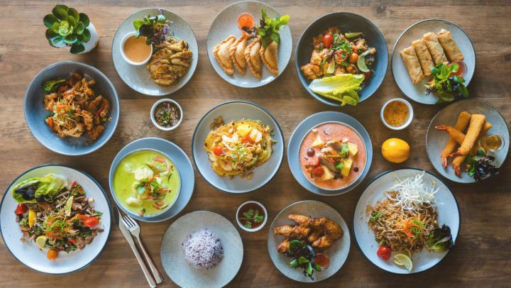 Aerial shot of different Thai plates on a wood table