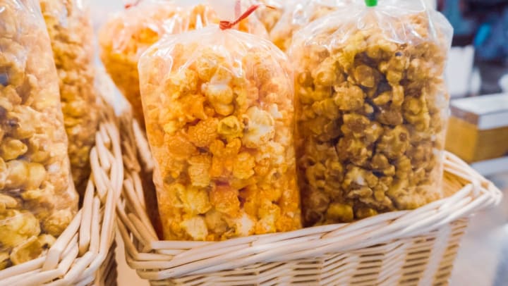 bags of flavored popcorn on a tray | Pompano Beach treat shops