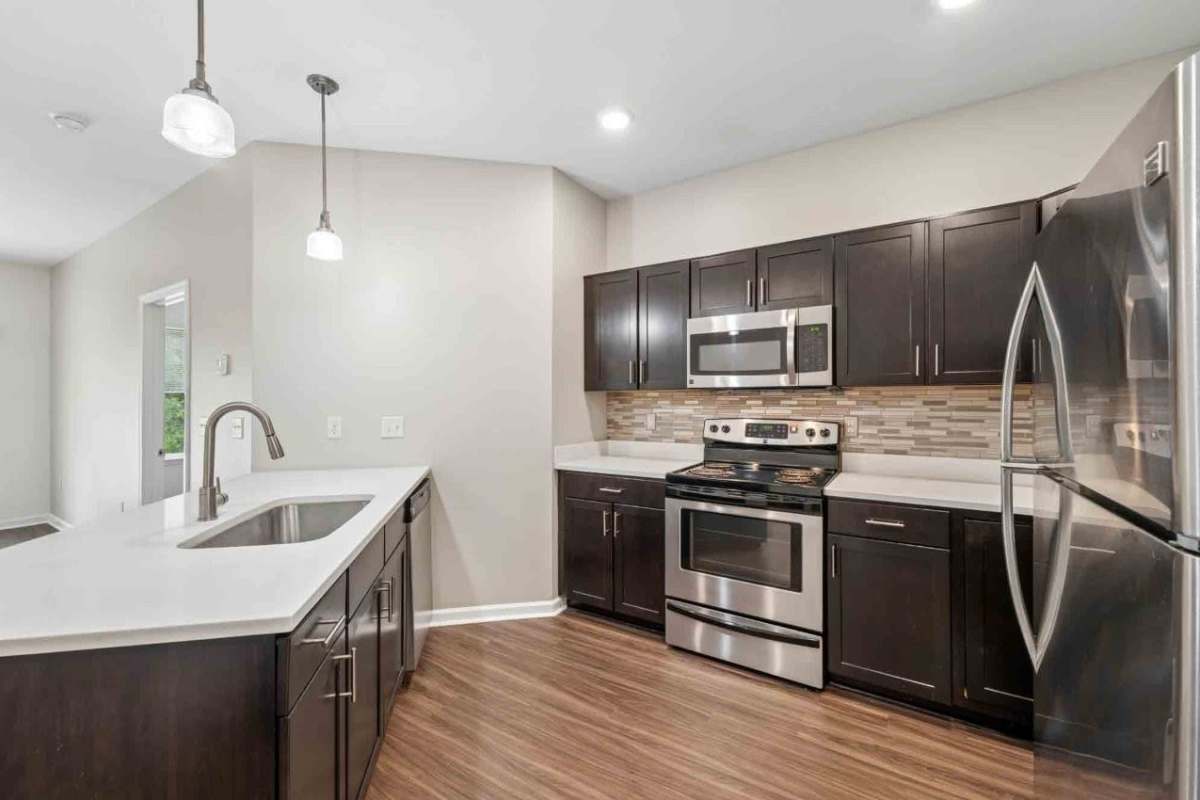 Beautiful modern kitchen with a breakfast bar and dining area at The Links at CenterPointe Townhomes in Canandaigua, New York