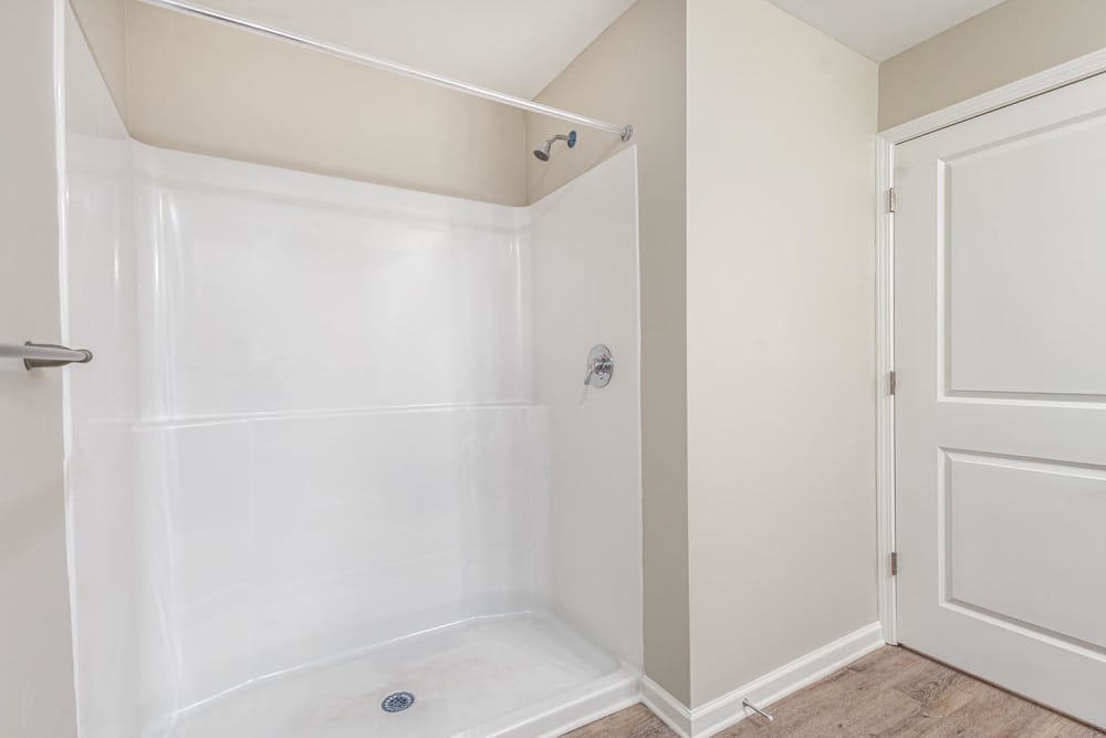 Spacious shower with modern fixtures and wood-style flooring at Galloway Crossing in Charlotte, North Carolina