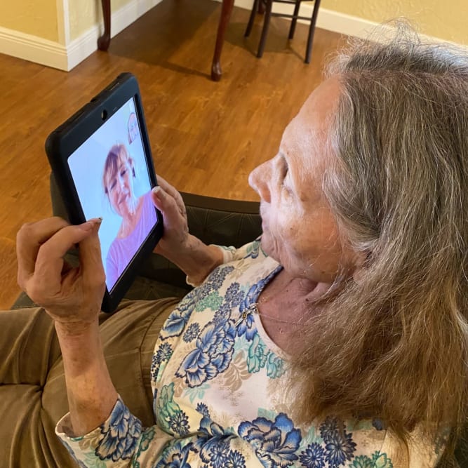 Resident video chatting relative at Grand Villa of Largo in Largo, Florida