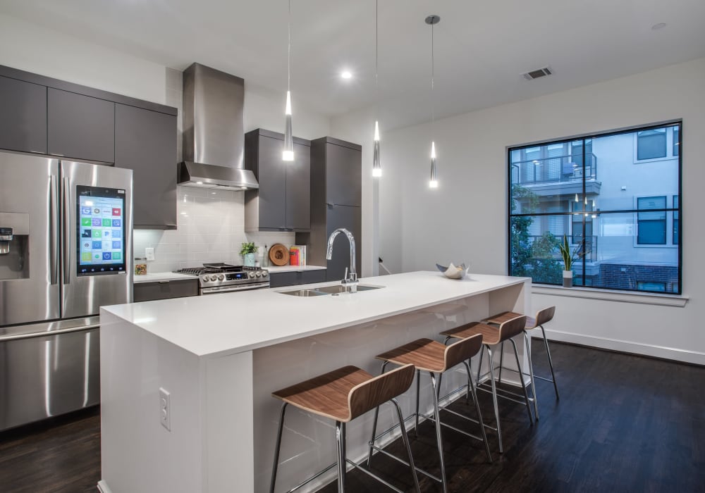 Trendy apartment kitchen with smart fridge at The Collection Townhomes in Dallas, Texas