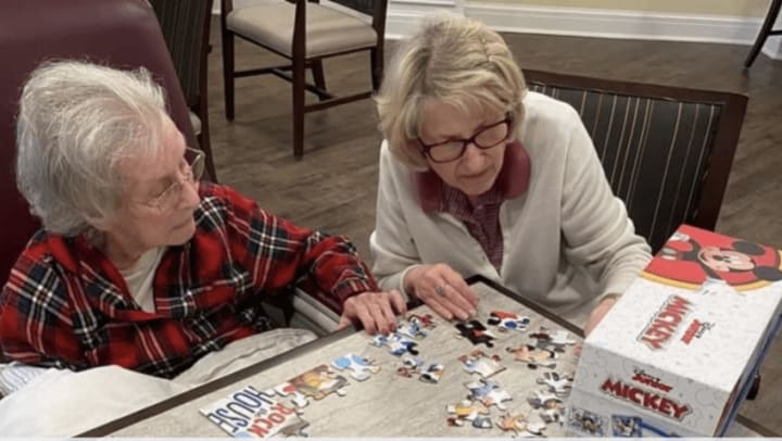 two women in harmony square building a puzzle