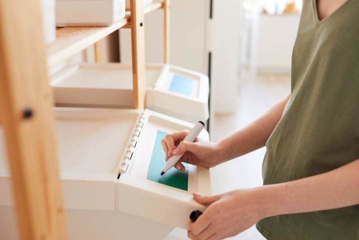 Woman organizing attic storage with plastic bins with labels