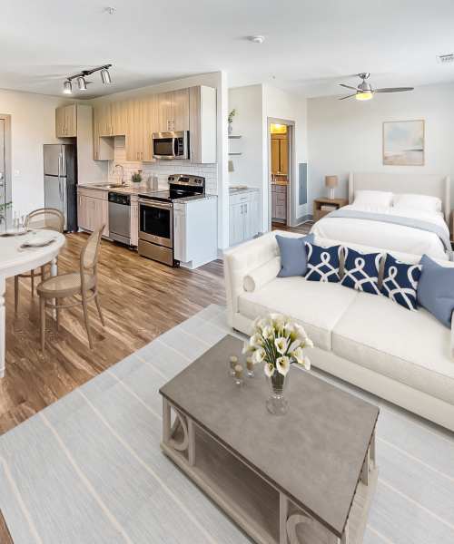 Living room with cream upholstered sofa next to the kitchen at The Dartmouth North Hills in Raleigh, North Carolina