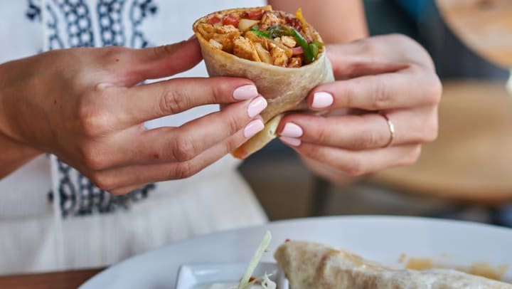 Woman holding a burrito at Olympus Grand Crossing in Katy, Texas