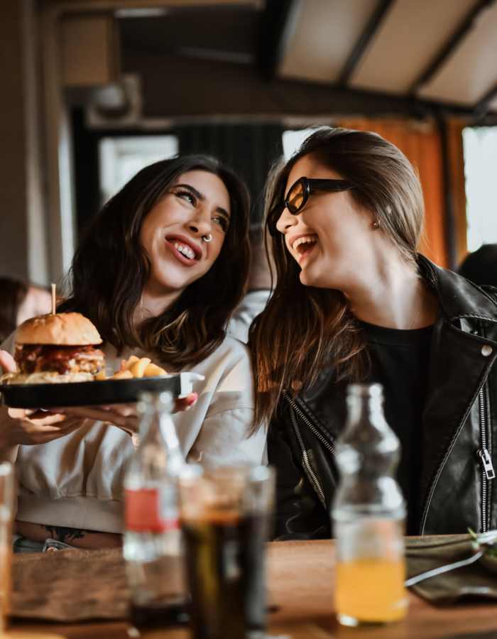 Student friends enjoying delicious hamburgers outside on a beautiful day near Brookside Downtown in Columbia, Missouri