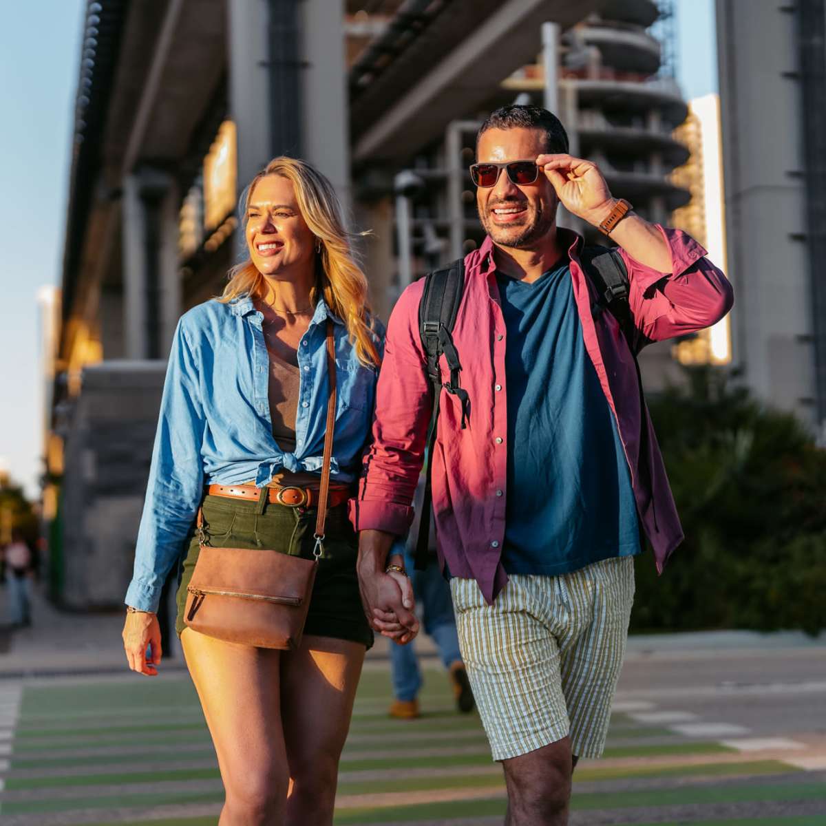 Couple walking hand in hand near St Tropez Apartments in Marina Del Rey, California 