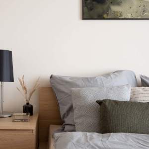 Cozy bedroom with soft linens and modern lamp at Standard at Royal Lane in Dallas, Texas 