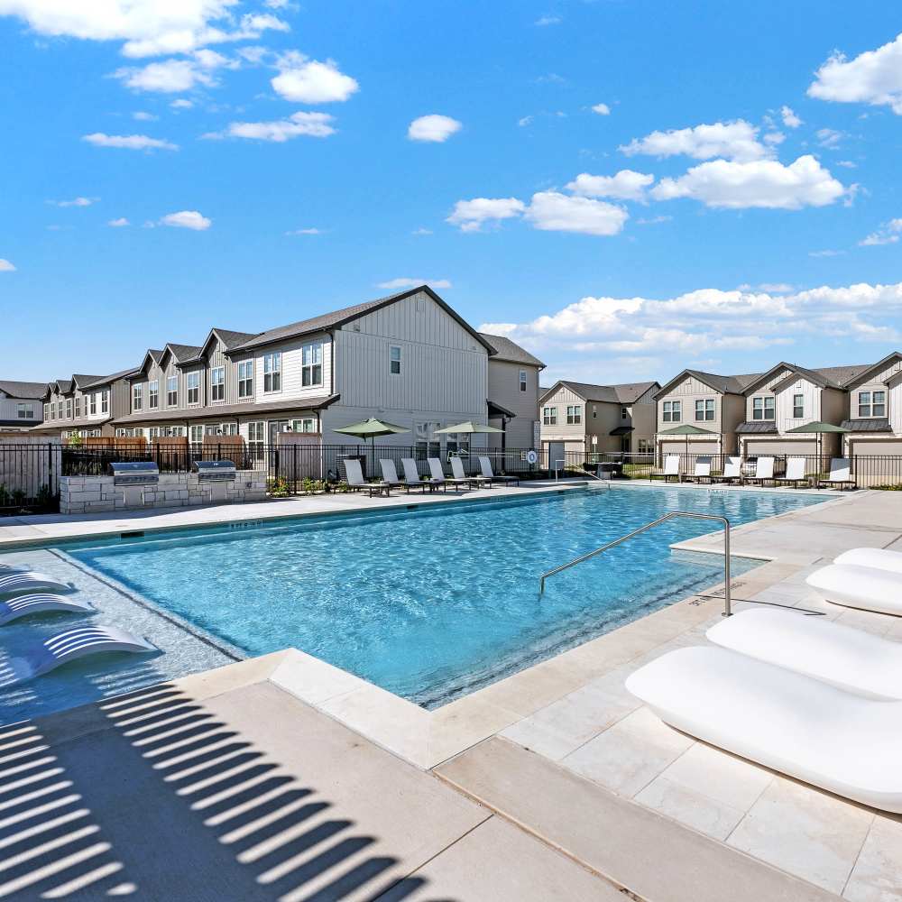 Resort-style pool with lounge chairs at Caliza at The Loop in San Antonio, Texas