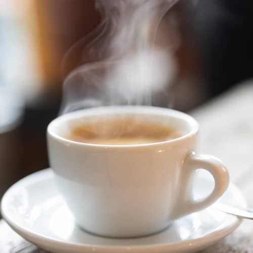 Steaming cup of coffee on a saucer at The Lofts On First in The Plains, Ohio