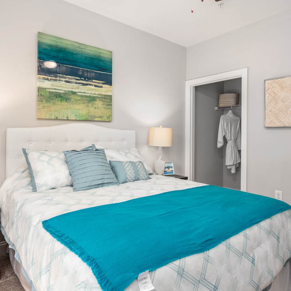 Bedroom With Blue Blanket And Artwork at Retreat at the Park in Burlington, North Carolina