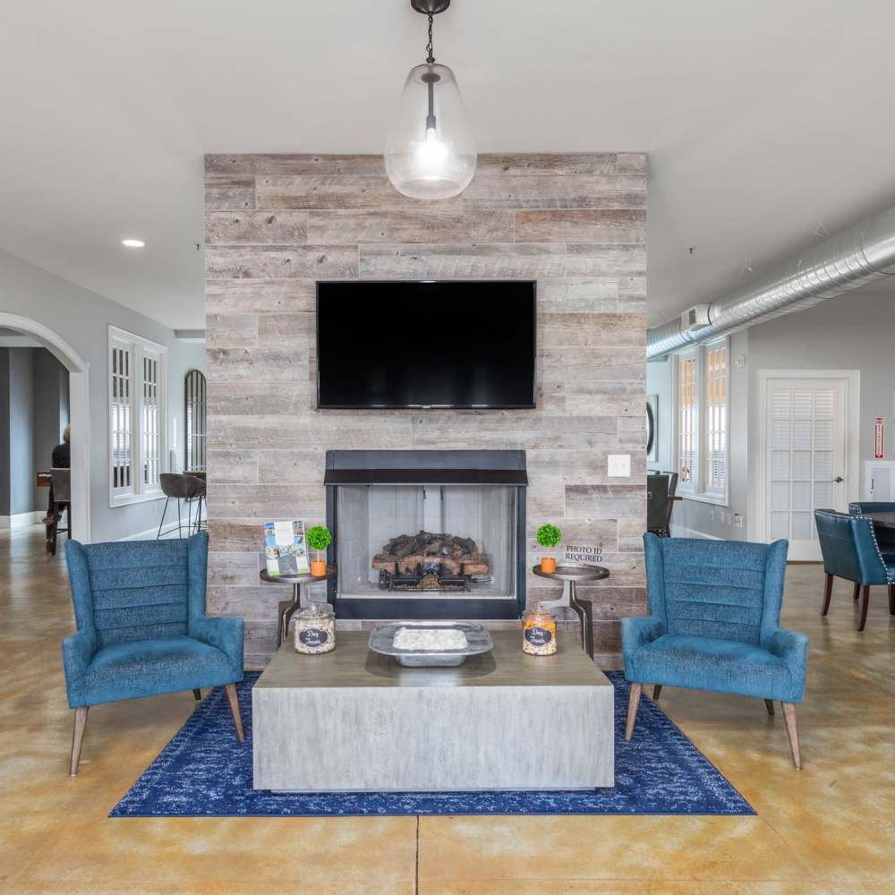 Living Area With Fireplace And Blue Chairs at Retreat at the Park in Burlington, North Carolina