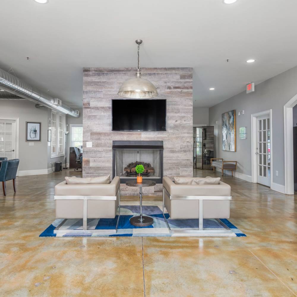 Living Area With Fireplace And Tan Chairs at Retreat at the Park in Burlington, North Carolina
