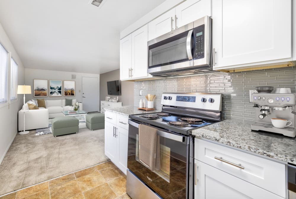 Contemporary kitchen with white cabinetry and stainless-steel appliances at Idylwood Resort Apartments in Cheektowaga, New York