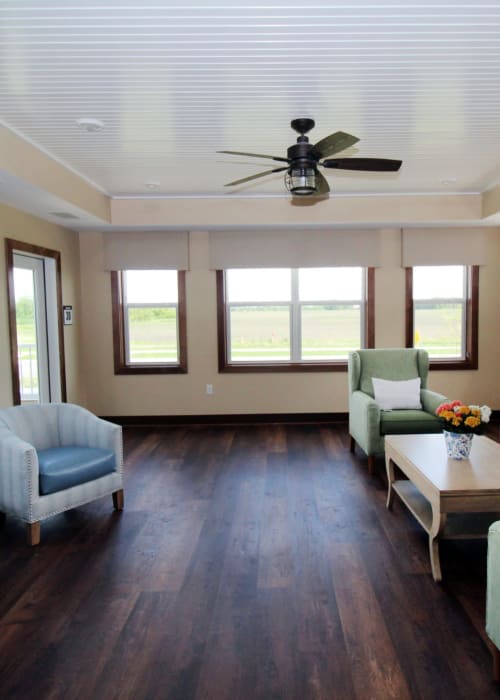 Sunroom with ceiling fan, sofa, and chairs at The Pillars of Mankato in Mankato, Minnesota