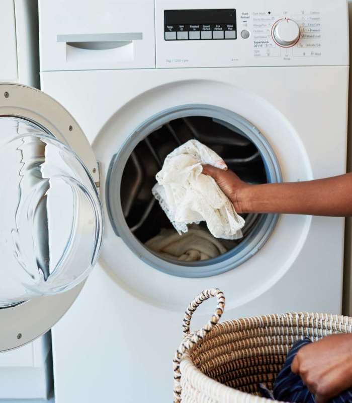 Resident using washing machine at Woodfield Heights Apartments in Waukesha, Wisconsin