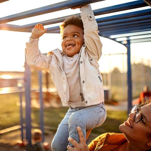 Young boy playing in a playground at Crystal Lake Apartments in Crystal Lake, Illinois