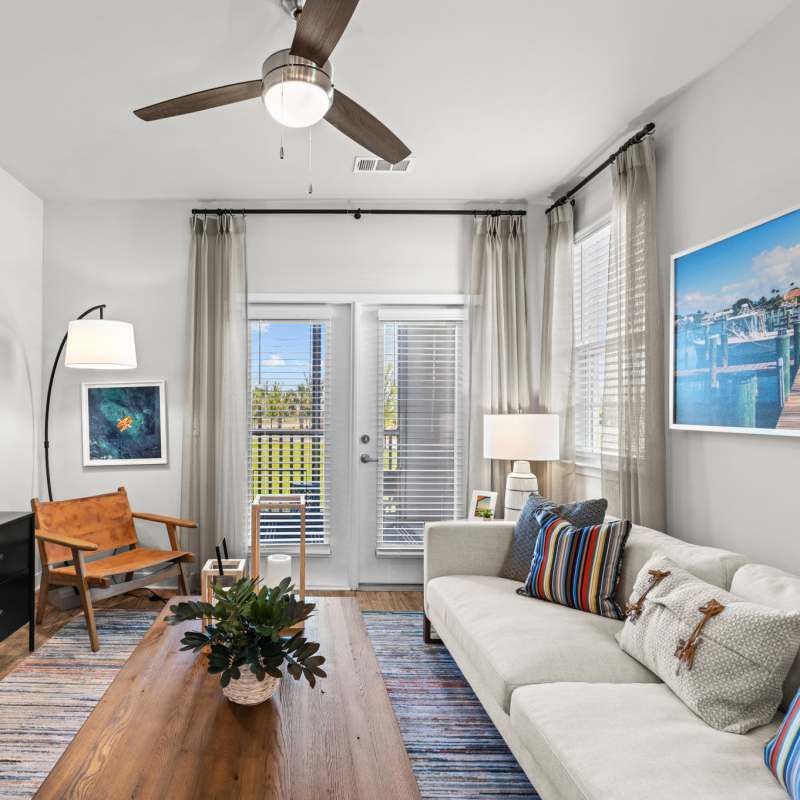 Beautifully finished hardwood flooring and modern furnishings in a model apartment's primary bedroom at Mexico Beach Crossings in Mexico Beach, Florida