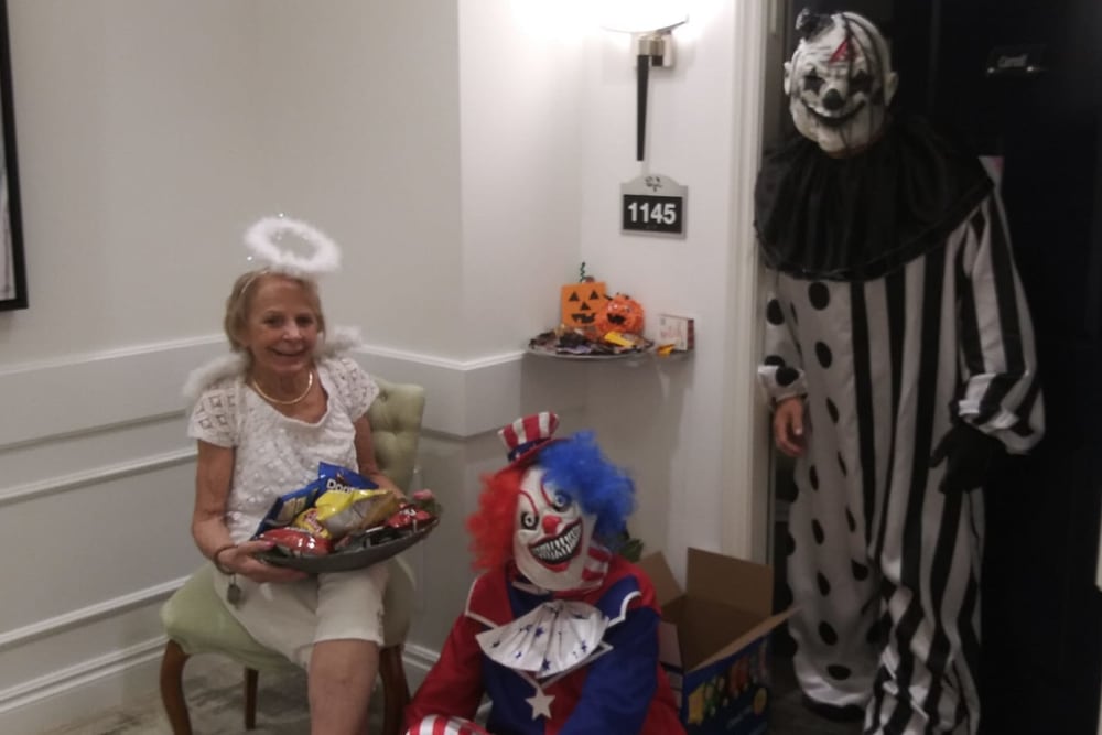 Lady handing out Halloween candy with clowns at Blossom Ridge in Oakland Charter Township, Michigan