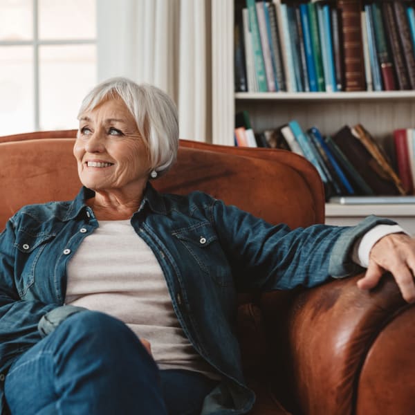 A woman lounging in a comfy chair at Pacifica Senior Living Sterling in Sterling, Virginia