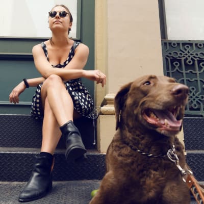 A women hanging out with her dog on the front steps at 210-220 E. 22nd Street in New York, New York