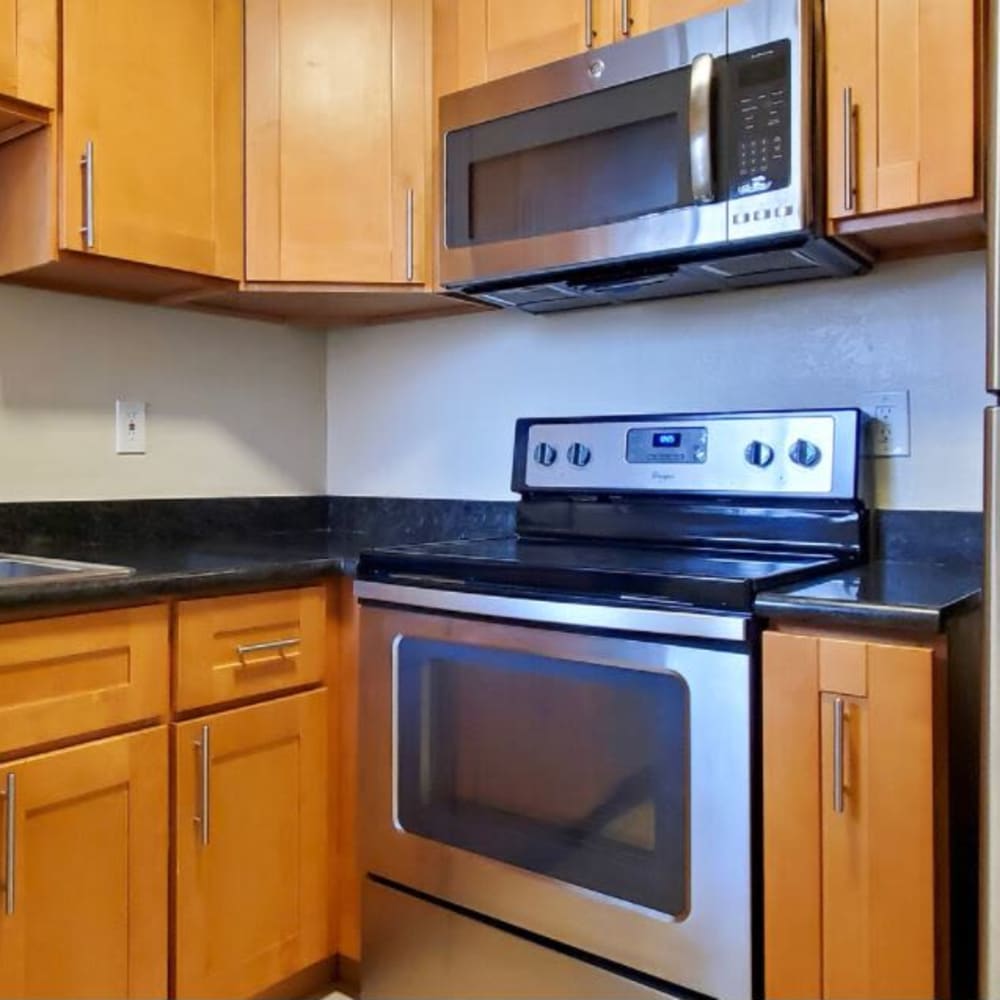 Kitchen with stainless steel appliances and granite countertops at Mission Rock at Marin in San Rafael, California