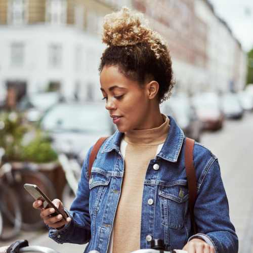 Female biker using a smartphone on the go to shop near Edge DTC in Denver, Colorado